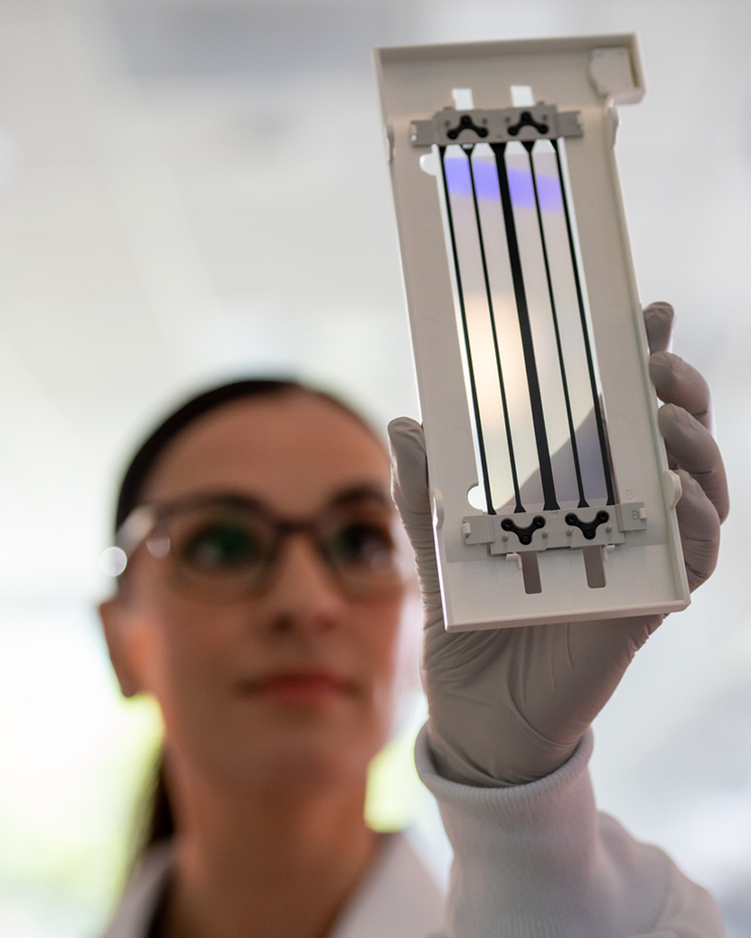 Scientist in lab with NovaSeq 6000Dx flow cell