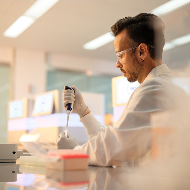 scientist pipetting with nextseq 1k 2k in background