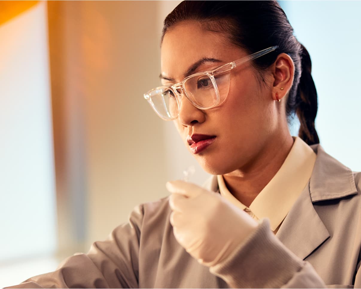 Female scientist, front side view, holding clear liquid in tube, recording data