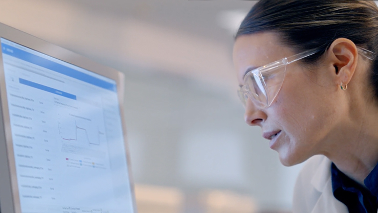 Scientist looking closely at the screen of a NextSeq 1000/2000 sequencer